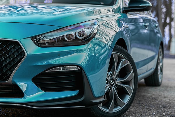 Detailný pohľad na modré hatchback vozidlo s výraznými LED svetlami a športovými diskami, ponúkané v rámci predaj jazdených vozidiel.
