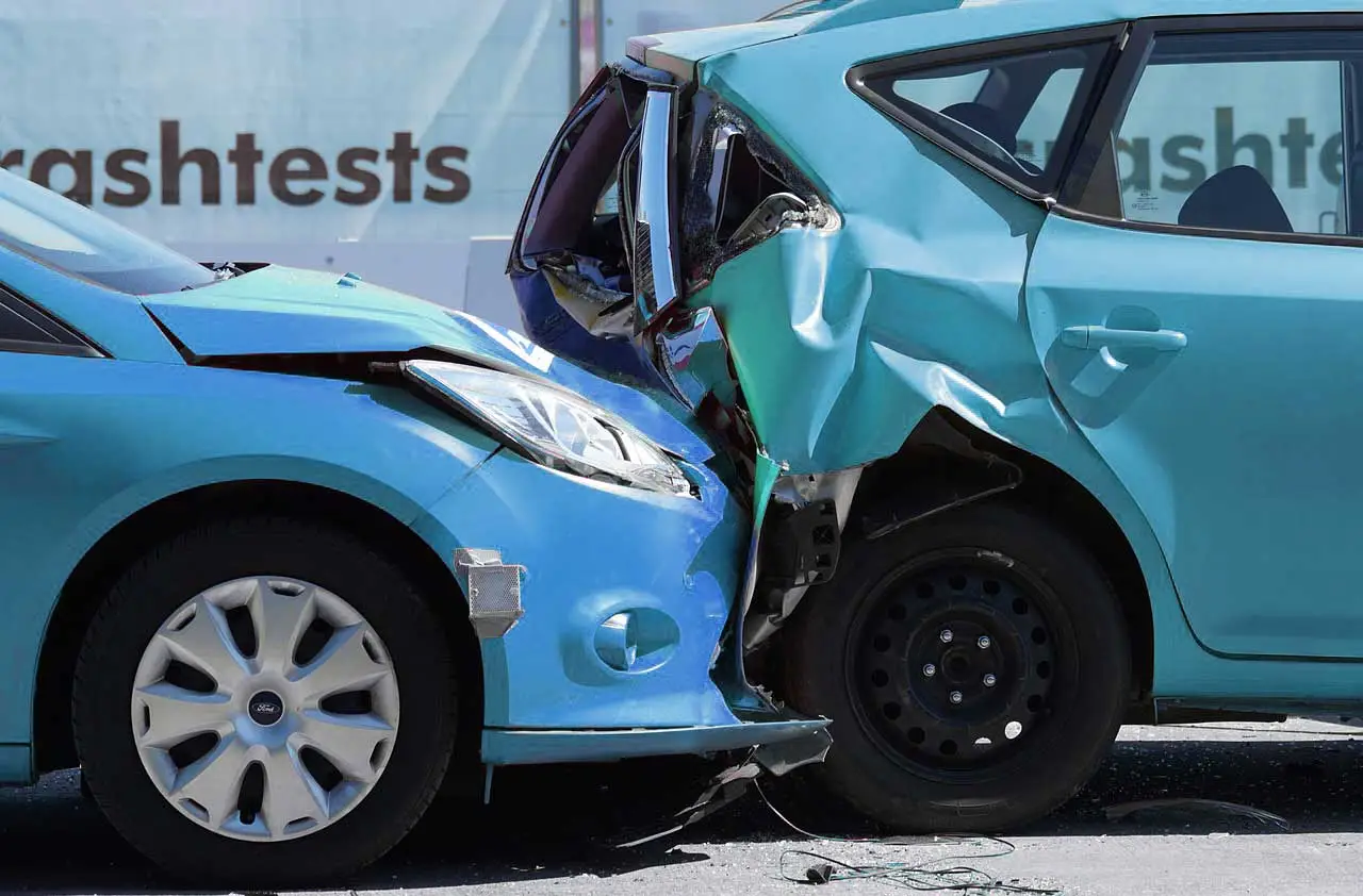 Poškodené modré auto po nárazovom teste, ktoré zdôrazňuje význam bezpečnostných prvkov a spoľahlivosti v automobilovom priemysle.